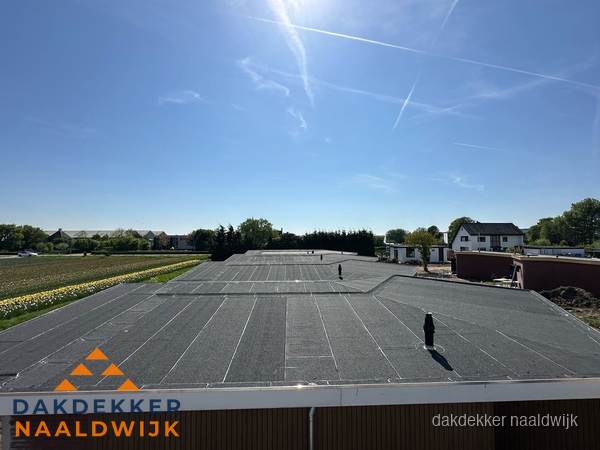 Groot plat dak met bitumen dakbedekking op bedrijfspand in Naaldwijk