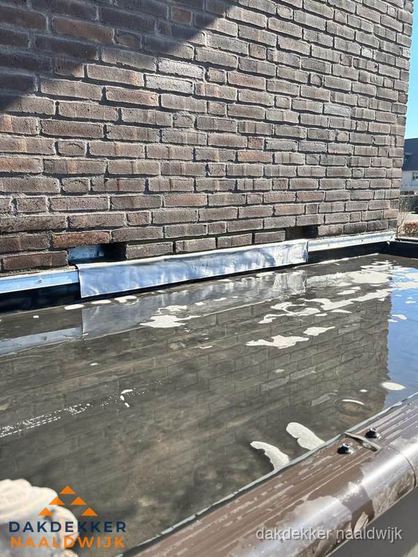 Stilstaand water op plat dak door slechte afwatering in Naaldwijk Stilstaand water op plat dak door slechte afwatering in Naaldwijk
