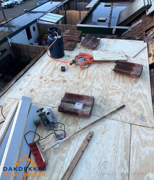 Dakreparatie werkzaamheden op plat dak met gereedschap in Naaldwijk