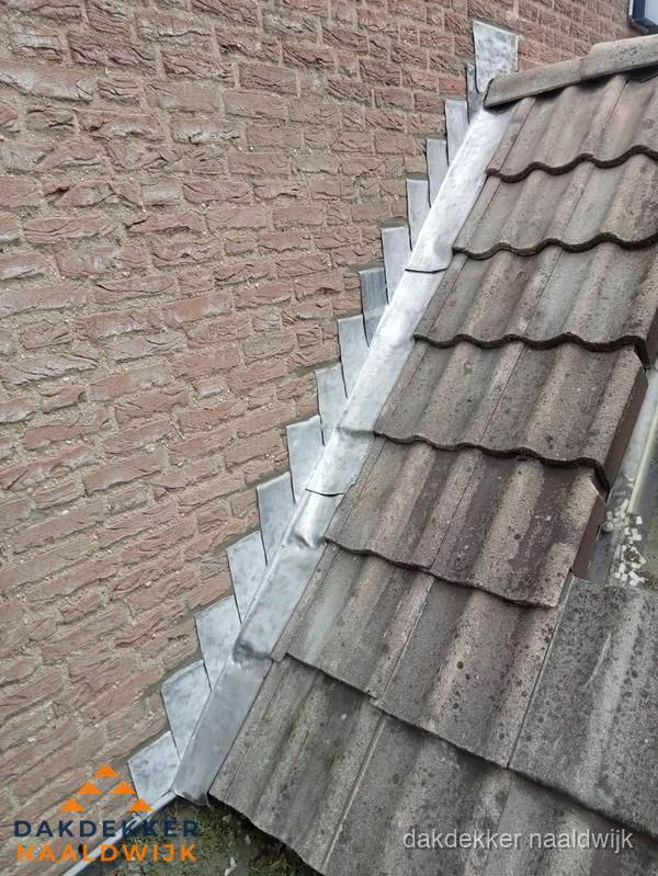 Loodslabben langs dakaansluiting bij bakstenen muur in Naaldwijk