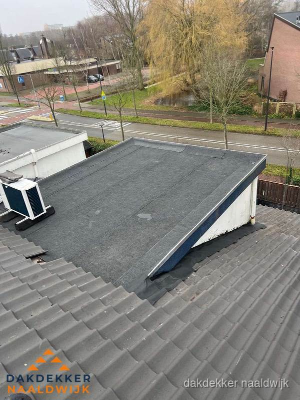 Plat dak met bitumen dakbedekking naast schuin pannendak in Naaldwijk Plat dak met bitumen dakbedekking naast schuin pannendak in Naaldwijk