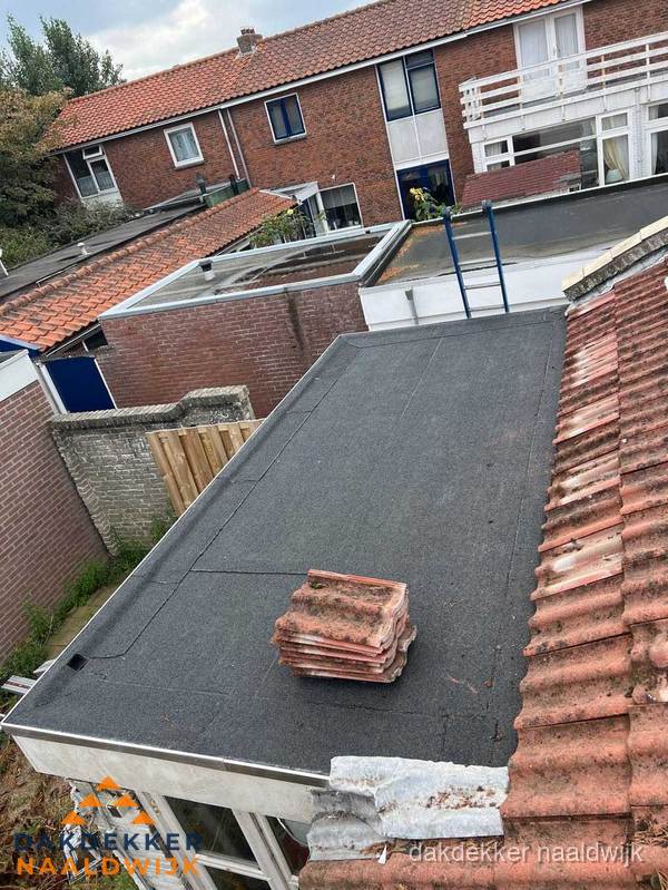 Plat dak aanbouw met bitumen naast schuin pannendak in Naaldwijk Plat dak aanbouw met bitumen naast schuin pannendak in Naaldwijk