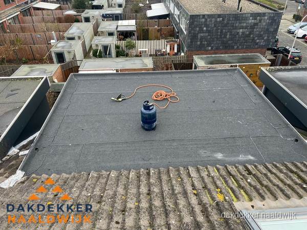 Plat dak met bitumen dakbedekking en brander in Naaldwijk