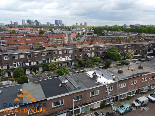 Spoed dakdekker aan het werk op plat dak in woonwijk Naaldwijk