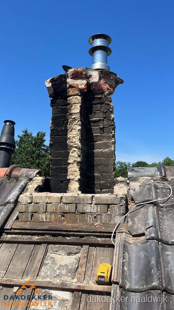Beschadigde schoorsteen met nieuwe rookgasafvoer op oud dak in Naaldwijk Beschadigde schoorsteen met nieuwe rookgasafvoer op oud dak in Naaldwijk